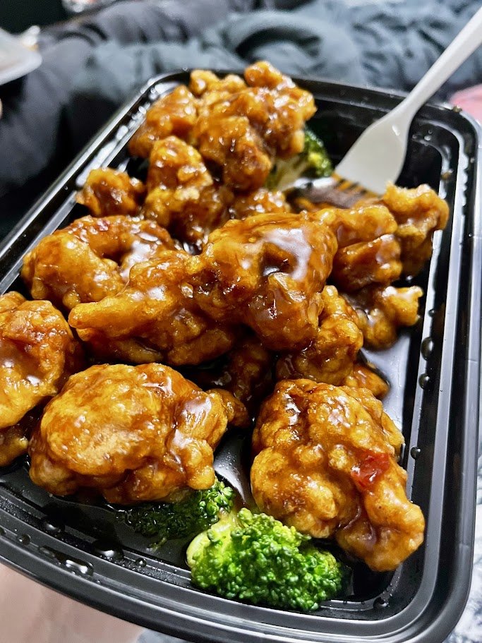 Plates of Chinese takeout on a table.